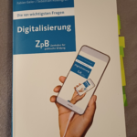 Buchcover: Die 101 wichtigsten Fragen: Digitalisierung, abgebildet ist eine Hand, die ein Smartphone hält, auf dessen Display wiederum das Buchcover abgebildet ist